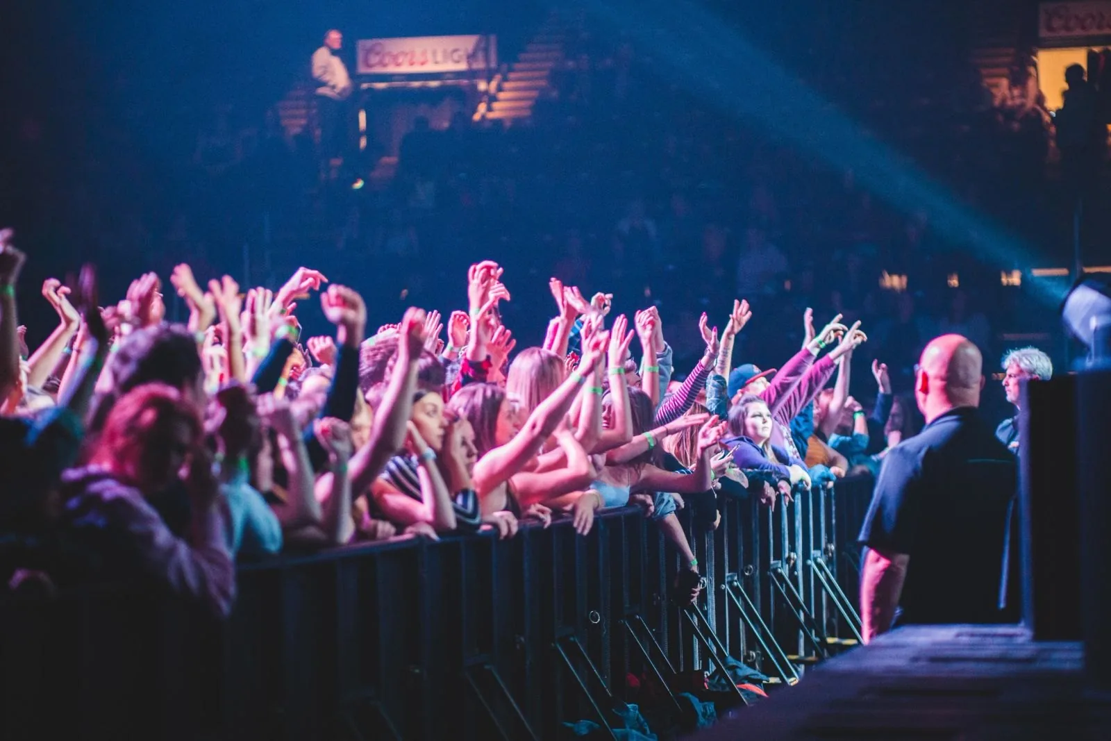 Security officer standing watch at the front barricade of a packed concert